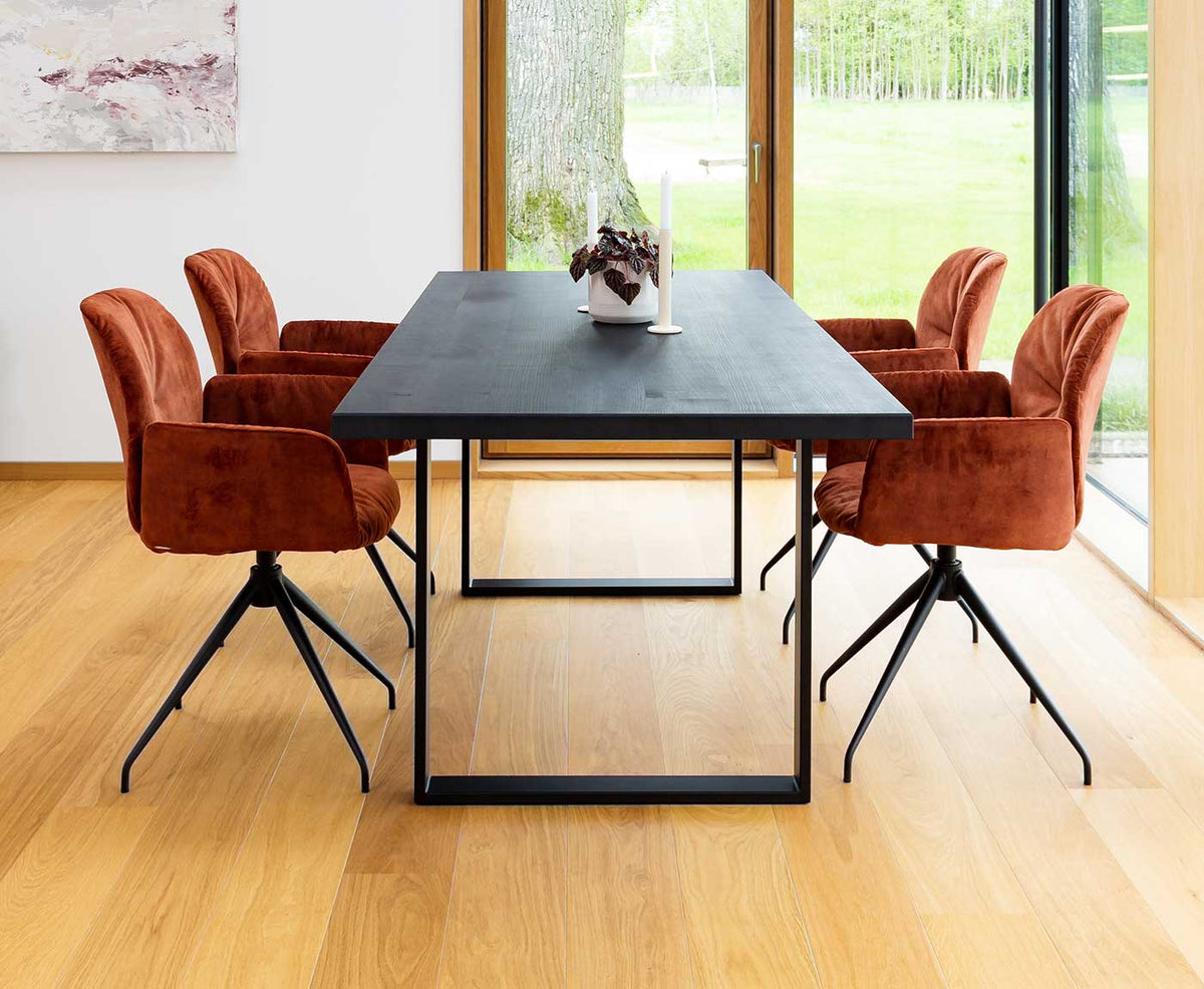 Schwarze Tischplatte aus Holz mit Gestell und Stühlen von vorne