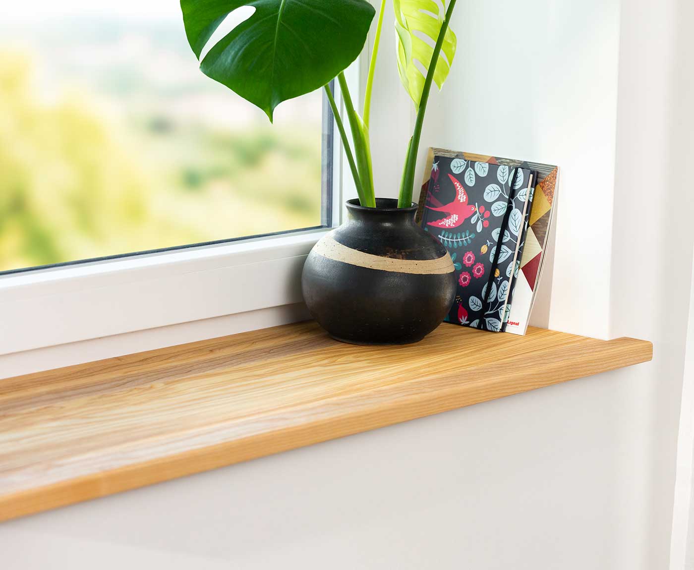 Fensterbank innen in Esche Premium im Fensterrahmen mit Deko und Zeitschriften.