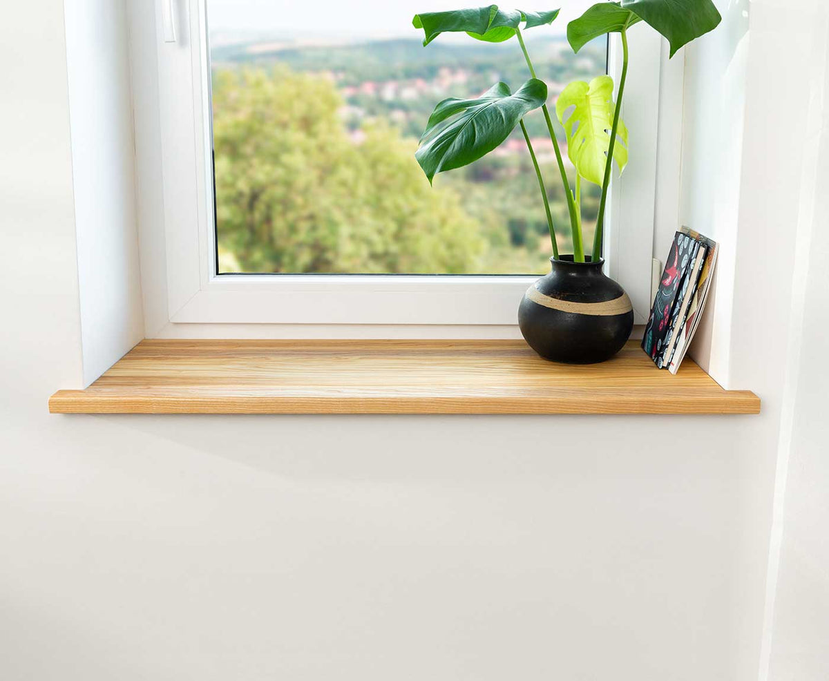 Fensterbank innen in Esche Premium im Fensterrahmen mit Deko und Zeitschriften.