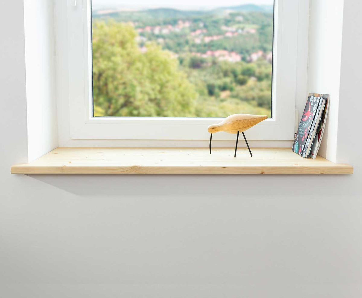 Fensterbank Fichte mit Holzvogel und Magazinen dekoriert.