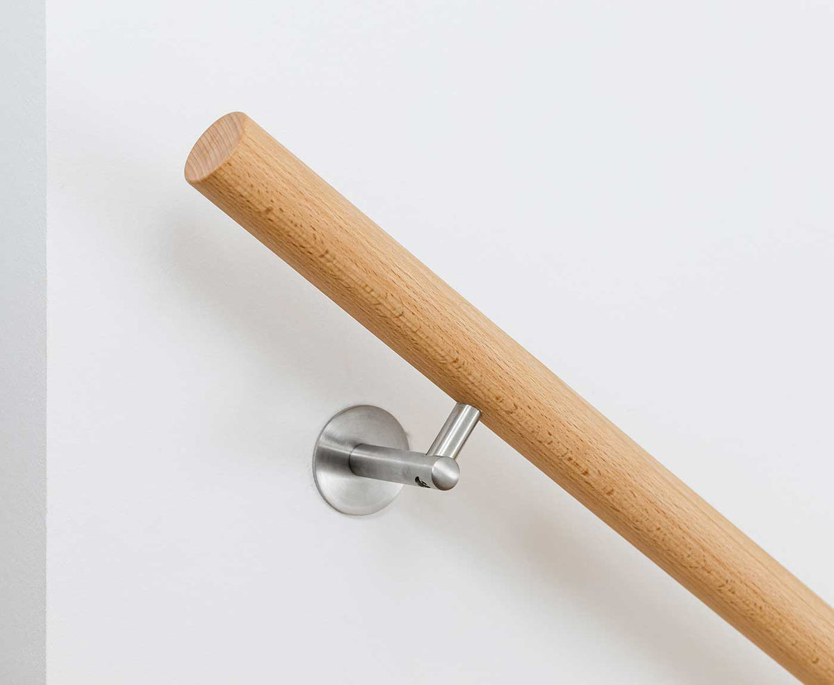 Nahaufnahme eines Massivholz Handlaufs in Buche mit Halterung aus Edelstahl.