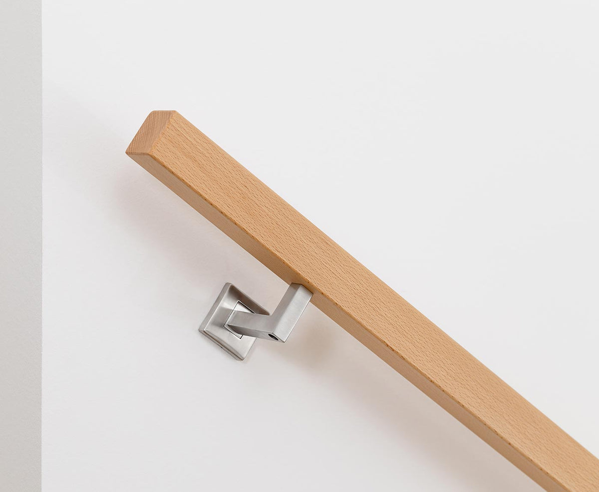 Detailansicht eines quadratischen Handlauf aus Buche, mit modernem Halter aus Edelstahl montiert.