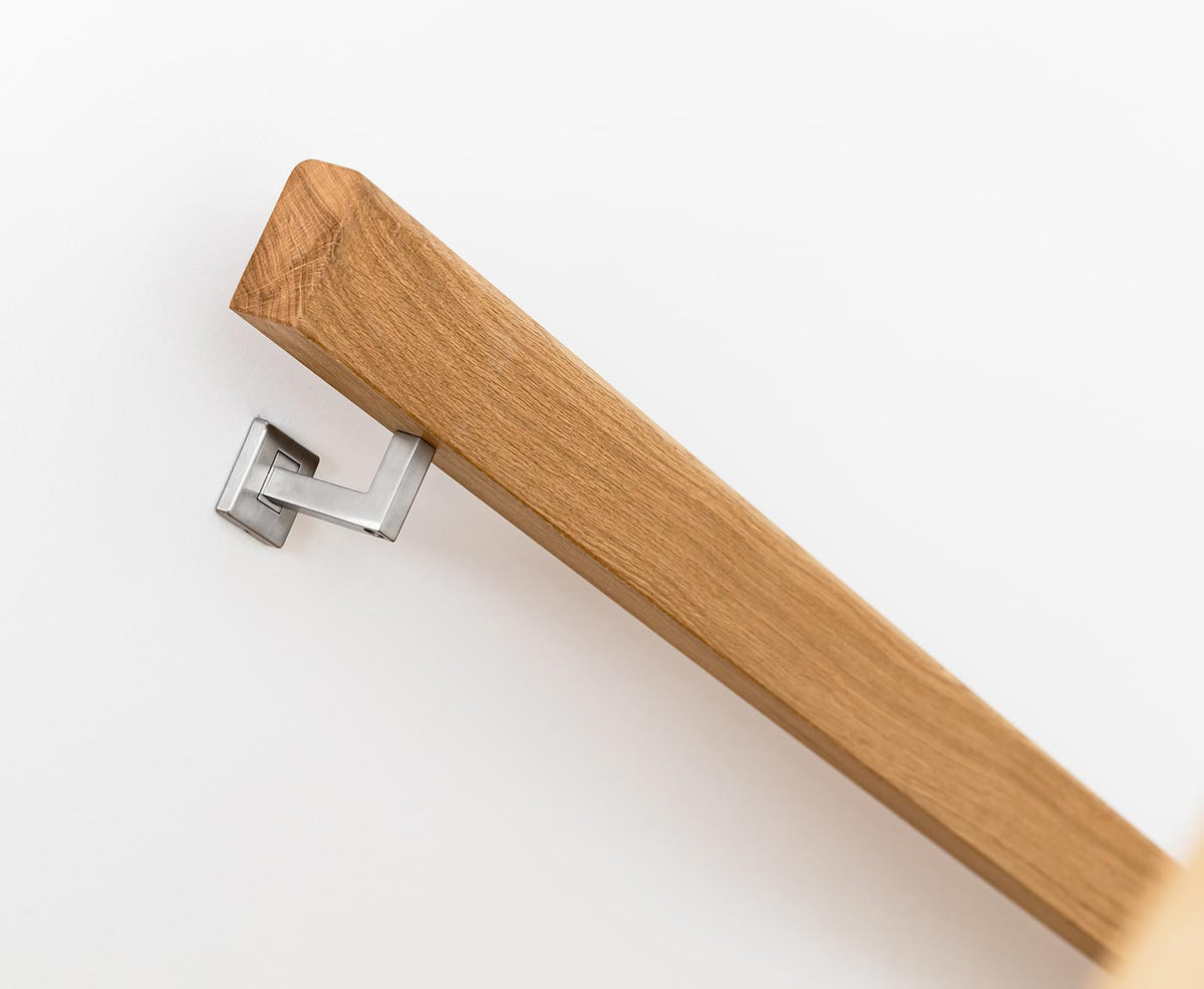 Nahaufnahme von Kopfende eines rechteckigen Handlaufs aus Eiche, befestigt durch Edelstahlhalter.
