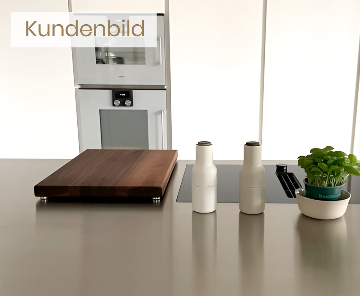 Kundenbild von Küchenbrett Holz Nussbaum mit Aluminium-Füßen, auf Küchenarbeitsplatte, mit Deko.